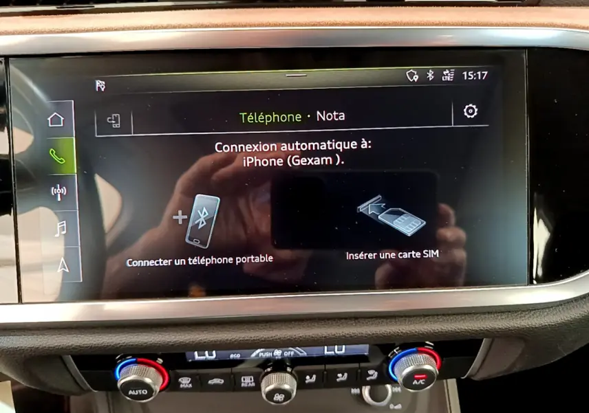 Écran tactile central affichant la connexion Bluetooth dans l'habitacle d'un Audi Q3 bleu, vue intérieure rapprochée.
