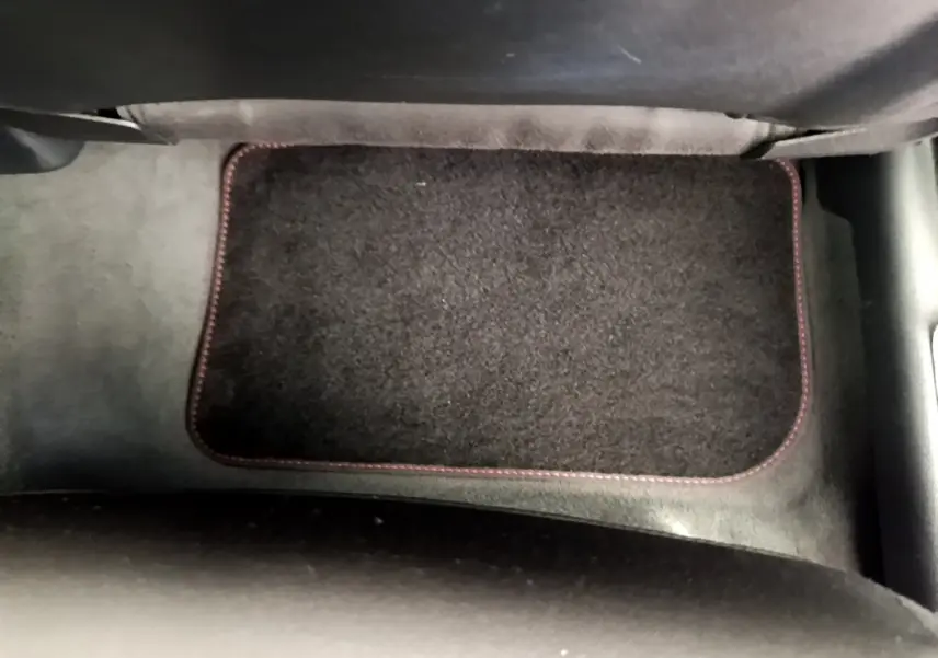 Tapis de sol noir avec surpiqûres rouges dans l'habitacle d'un Audi Q3 bleu 2020, vue du plancher côté passager.