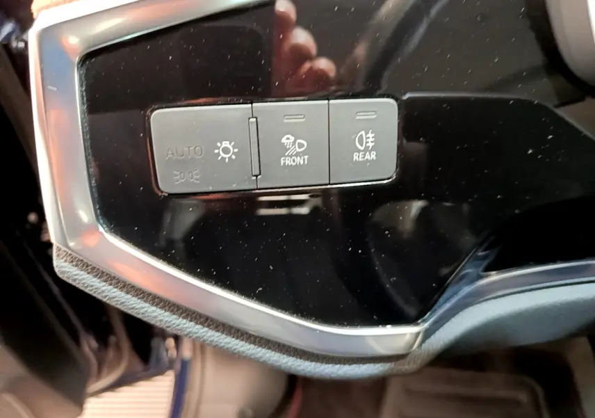 Gros plan sur les commandes d'éclairage du tableau de bord de l'Audi Q3 35 TDI bleu, version Business Line 2020.