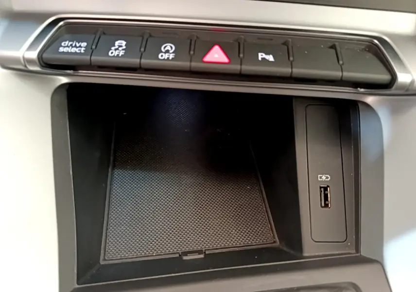 Gros plan sur la console centrale noire de l'Audi Q3 35 TDI 2020 avec boutons de contrôle et port USB visible.