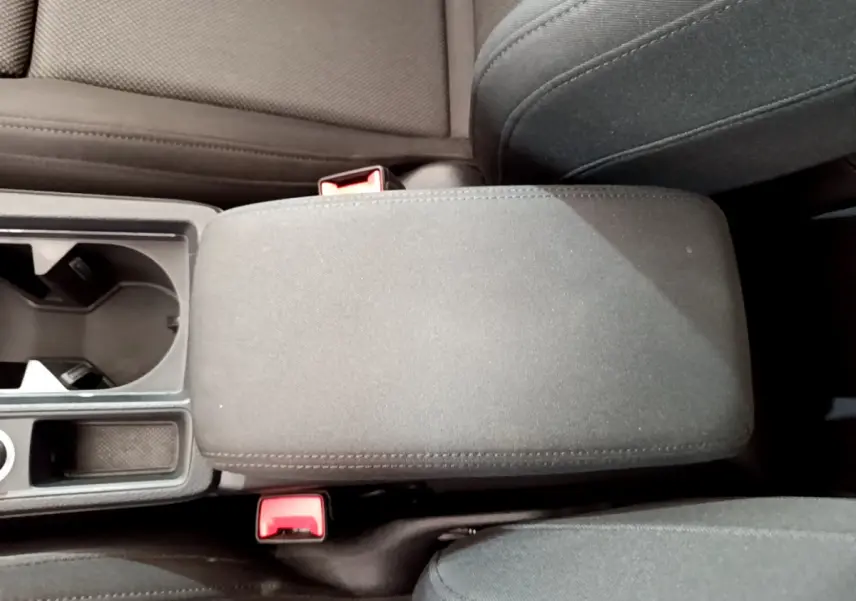 Vue rapprochée de l'accoudoir central et porte-gobelets noirs à l'intérieur de l'Audi Q3 bleu 2020.