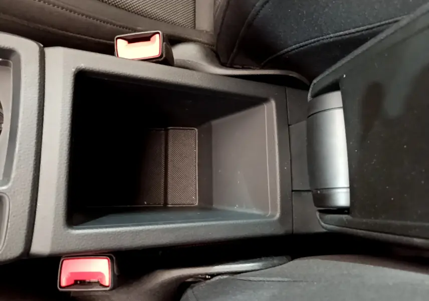 Gros plan sur le rangement central noir entre les sièges avant d'un Audi Q3 bleu 35 TDI 150 S Tronic Business Line.