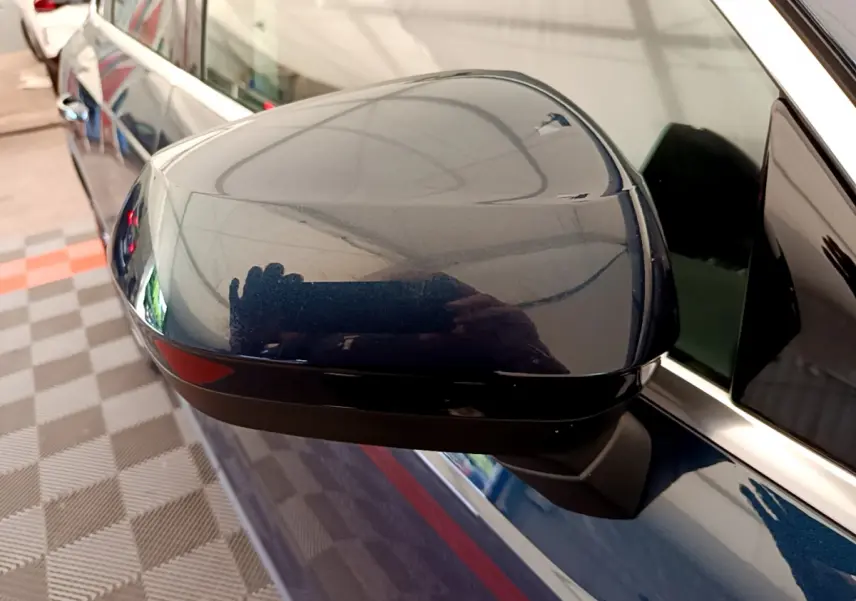 Rétroviseur côté gauche bleu métallisé de l'Audi Q3 35 TDI 150 S tronic Business Line 2020 avec clignotant intégré.