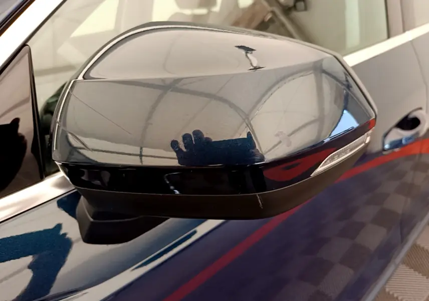 Rétroviseur côté gauche bleu foncé de l'Audi Q3 35 TDI 150 S tronic Business Line avec clignotant intégré.