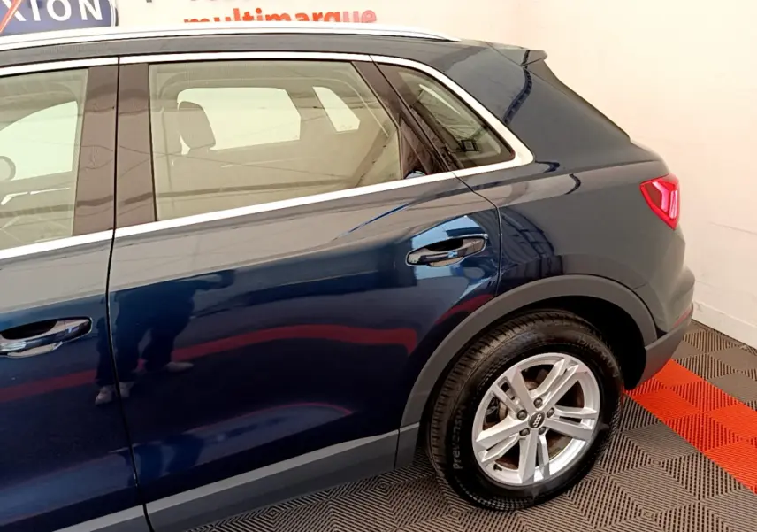 Vue latérale côté droit d'un Audi Q3 bleu 2020 avec jante alliage et feux arrière LED visibles.