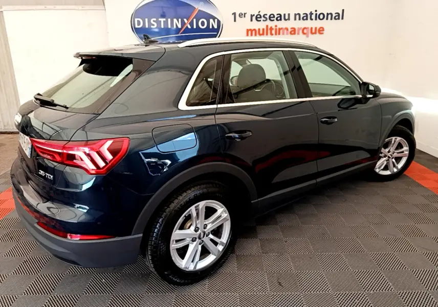 Audi Q3 bleu 35 TDI vue 3/4 arrière côté droit, avec feux arrière LED et jantes alliage argentées.