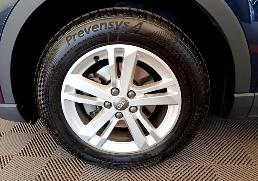 Gros plan sur la roue avant droite d’un Audi Q3 bleu 2020 avec jante argentée et pneu Prevensys 4 visible.