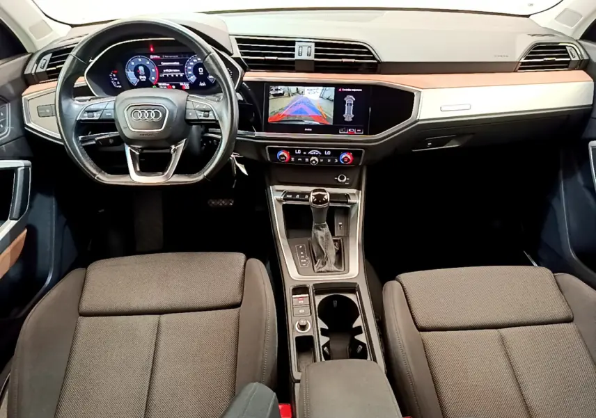 Intérieur Audi Q3 2020 vue de face, tableau de bord noir avec écran tactile et volant cuir multifonctions.