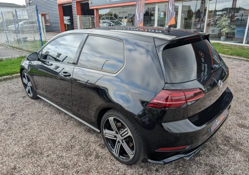 Vue 3/4 arrière droite d'une Volkswagen Golf noire 2017 avec jantes alliage 18 pouces et vitres teintées.