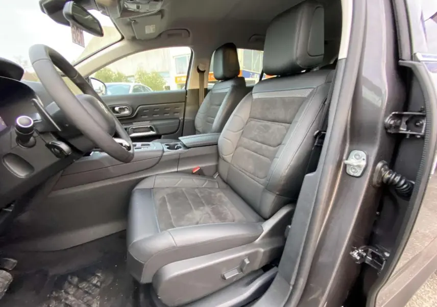 Vue intérieure côté conducteur du Citroën C5 Aircross 2025 gris platinium, sièges cuir et alcantara avec console centrale visible.