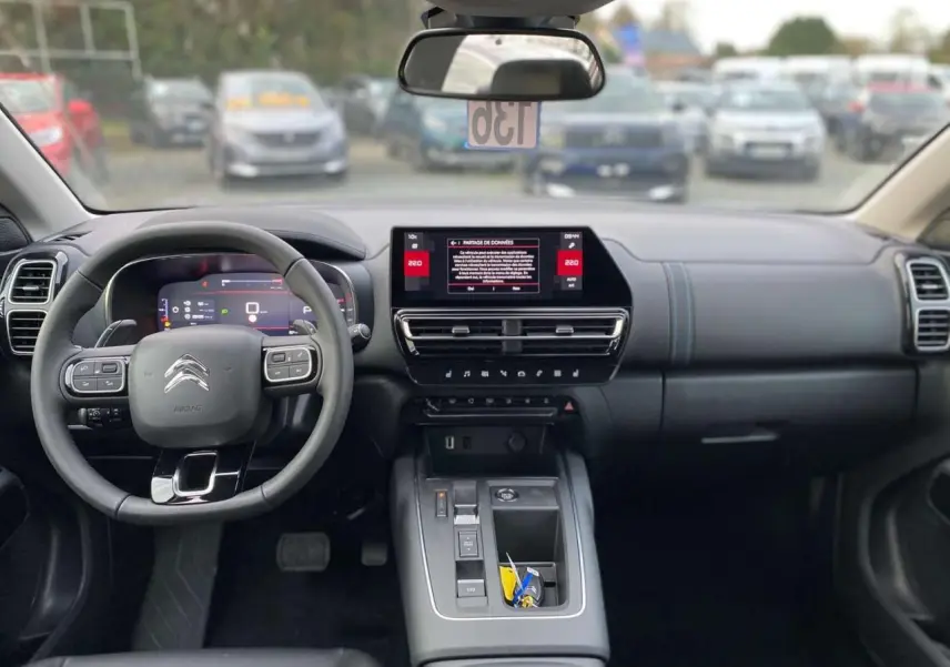 Vue intérieure avant du Citroën C5 Aircross gris platinium, tableau de bord moderne avec écran tactile 10 pouces et volant multifonction.