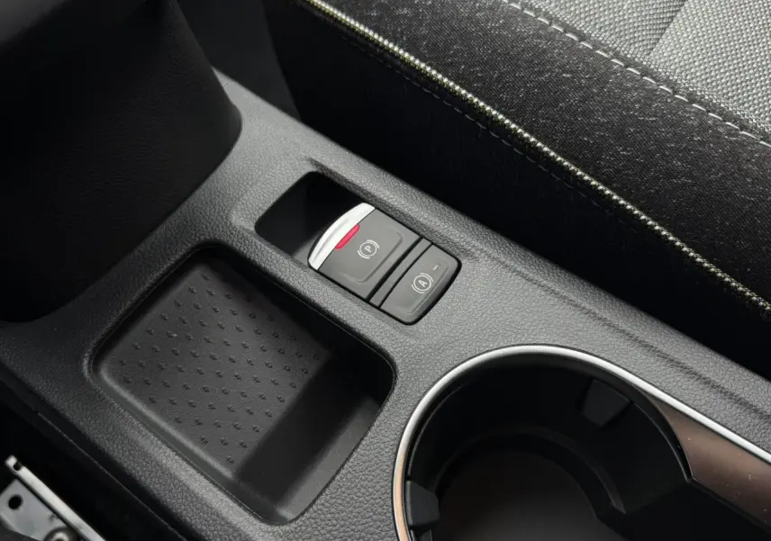 Gros plan sur la console centrale noire du Renault Captur 2026, avec bouton frein électrique et rangement à côté du siège.