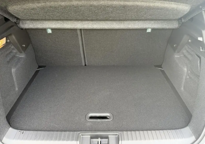Coffre ouvert vu de face du Renault Captur gris Rafale, montrant un espace de rangement propre et vide.