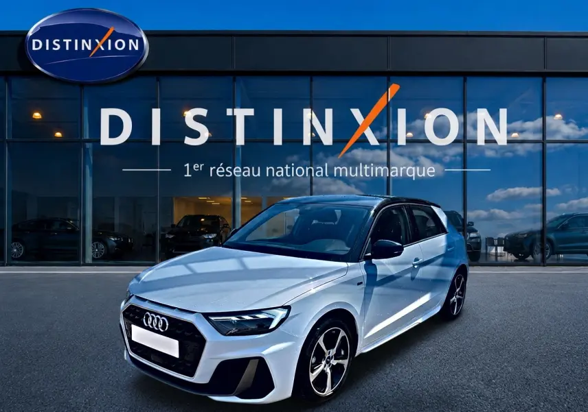 Audi A1 Sportback blanc et noir vue 3/4 avant droit, avec jantes alu et toit noir devant showroom Distinxion.