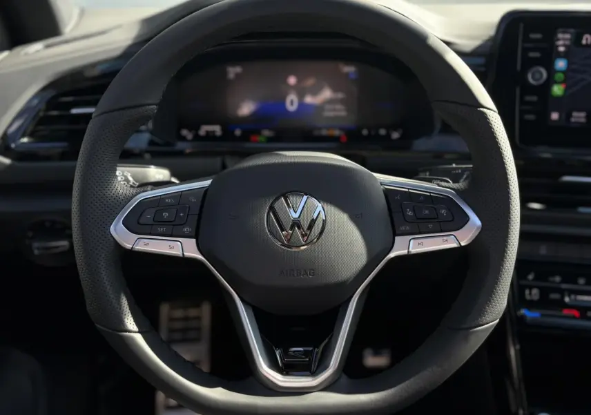Volant sport multifonction noir avec logo VW, vue frontale centrée sur le tableau de bord numérique du Volkswagen T-Roc.