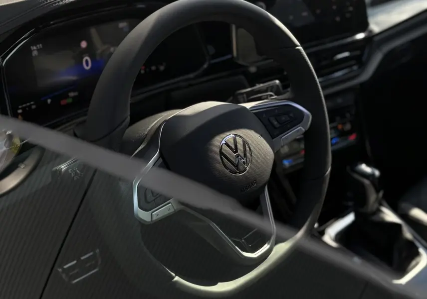 Gros plan sur le volant multifonction noir avec logo Volkswagen du tableau de bord du Volkswagen T-Roc 2025.