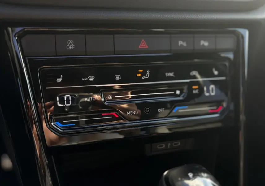 Panneau de commande de climatisation digitale du Volkswagen T-Roc noir Grenadilla, vue intérieure centrée sur les réglages.