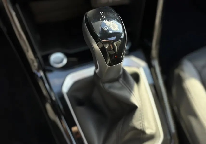 Le levier de vitesses automatique noir brillant du Volkswagen T-Roc 2.0 TDI R-Line vu en gros plan intérieur.