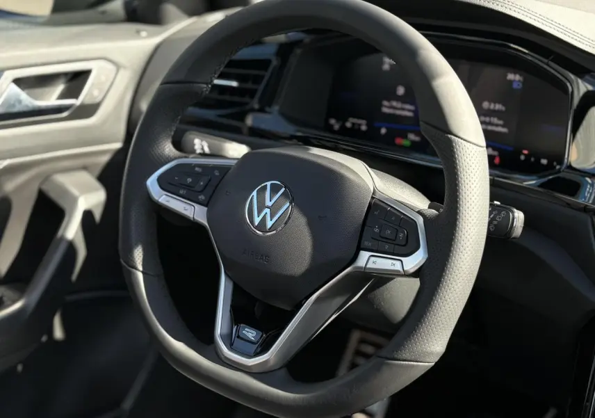 Volant sport multifonction noir avec logo VW, vue rapprochée de l'intérieur du Volkswagen T-Roc 2025 R-Line.