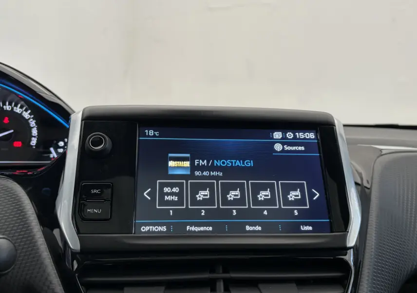 Écran tactile central affichant la radio FM dans l'habitacle du Peugeot 2008 rouge, vue de face rapprochée.
