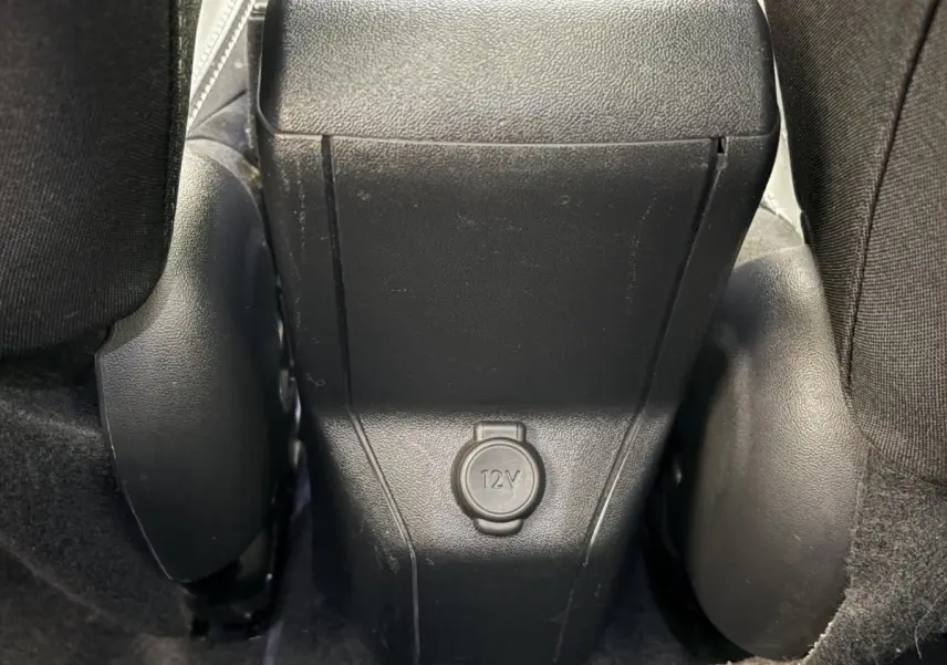 Prise 12V noire vue en gros plan entre les sièges arrière d'un Peugeot 2008 rouge version Puretech 2019.