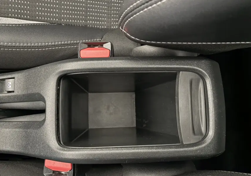 Vue plongeante sur le rangement central noir entre les sièges avant du Peugeot 2008 rouge 2019 Puretech Allure