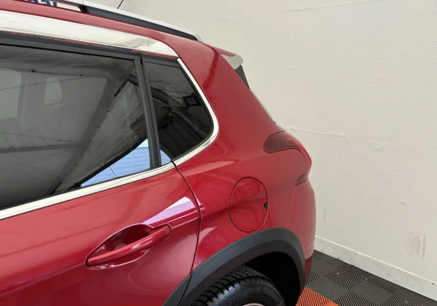 Gros plan sur l'arrière droit rouge vif du Peugeot 2008 2019 avec porte de réservoir et jante noire.