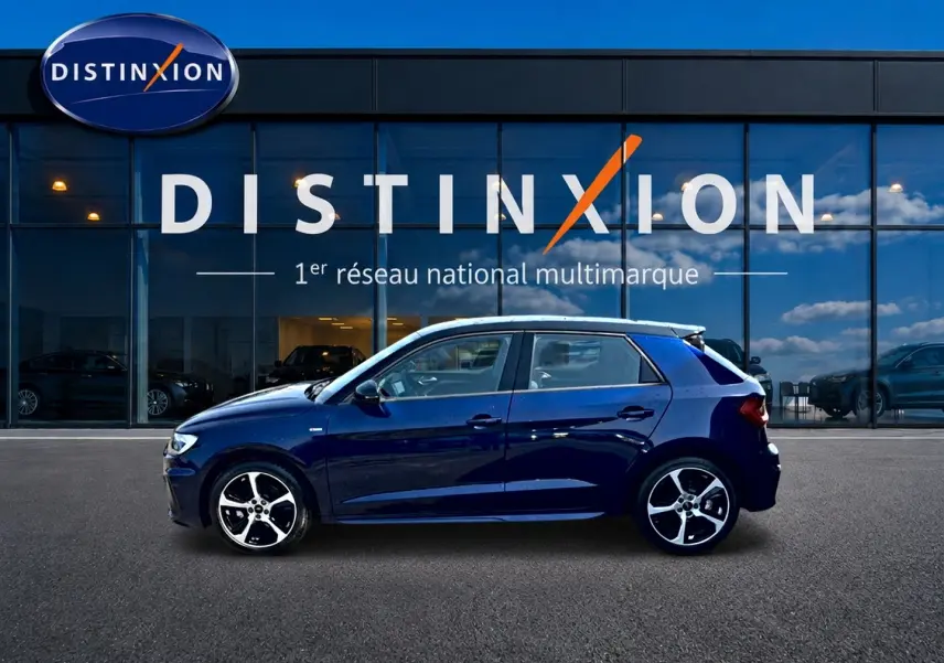 Audi A1 Sportback 30 TFSI bleu foncé vue de profil côté gauche devant une vitrine Distinxion.