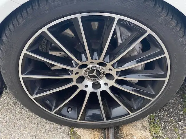 Gros plan sur la jante noire et argentée AMG d'une Mercedes Classe C 250D 9G-Tronic 2018, roue avant droite.