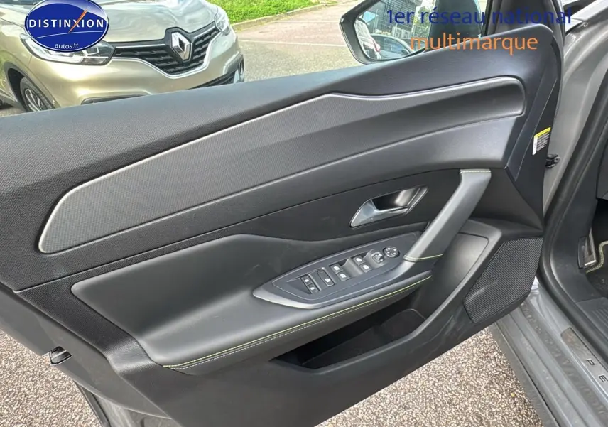 Vue intérieure de la porte avant gauche grise selenium du Peugeot 308 SW Phev 225 GT e-EAT8 avec commandes électriques.