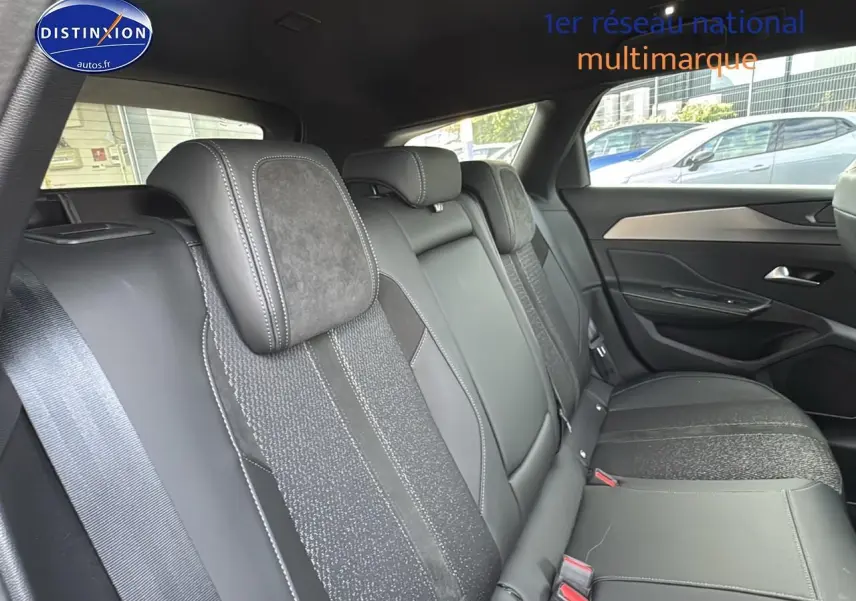 Vue intérieure sur la banquette arrière en cuir noir et tissu gris du côté droit d'une Peugeot 308 SW 2024.