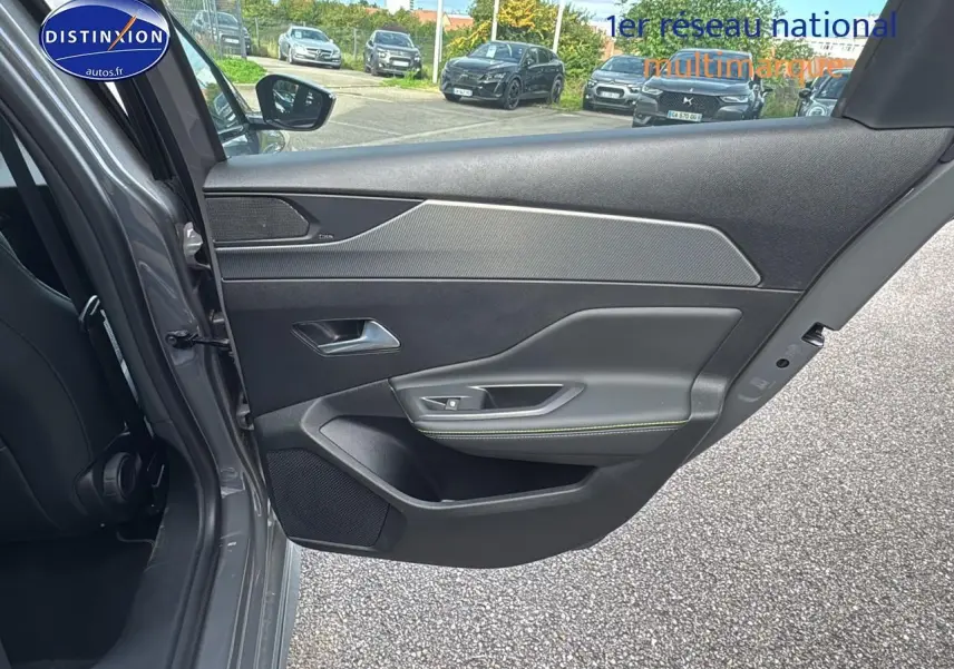 Porte arrière gauche ouverte d'une Peugeot 308 SW Phev 225 gt e-eat8 gris selenium, intérieur noir avec surpiqûres vertes.