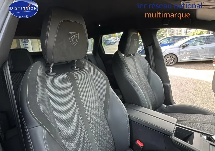 Intérieur montrant les sièges avant gris et noirs du Peugeot 308 SW Phev 225 GT e-EAT8, avec accoudoir central visible.