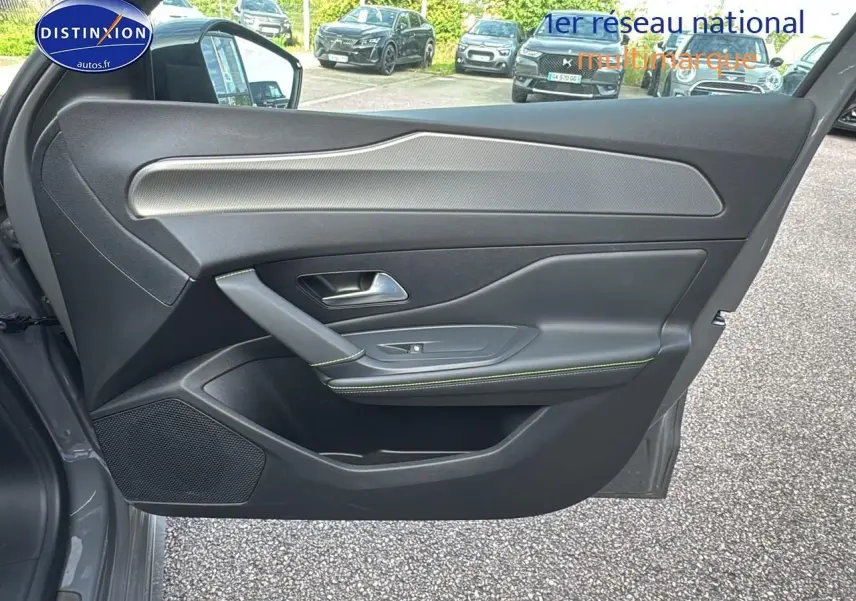 Porte côté gauche ouverte d'une Peugeot 308 SW Phev 225 GT gris selenium, intérieur noir avec surpiqûres vertes.