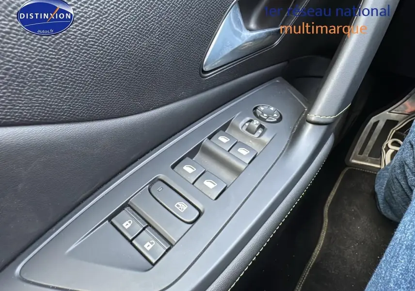 Gros plan sur la commande des vitres et serrures côté gauche intérieur d'une Peugeot 308 SW gris selenium 2024.