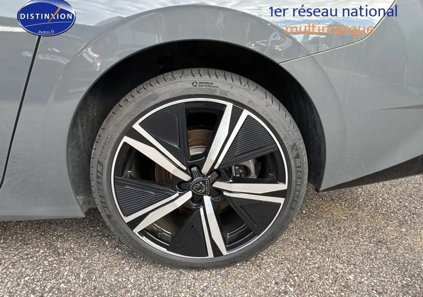 Gros plan sur la jante alu noire et argentée de la roue arrière droite d'une Peugeot 308 SW gris selenium.