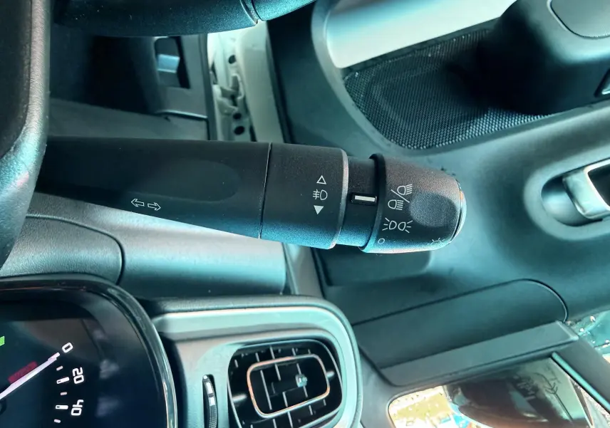 Gros plan sur la commande des phares et clignotants dans l'habitacle d'une Citroën C3 blanche de 2021.