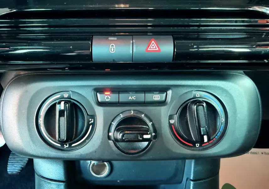 Panneau de commande de climatisation noir de la Citroën C3 III 1.5 BHDI 100, vue rapprochée du tableau de bord.