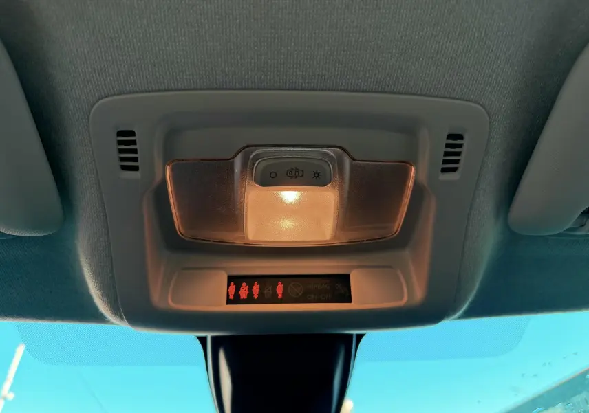 Plafonnier intérieur allumé avec voyants de ceinture de sécurité rouges dans une Citroën C3 blanche de 2021.