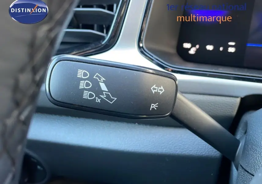 Gros plan sur la commande de clignotant à gauche dans l’habitacle du Volkswagen T-Roc gris pyrite 2025.