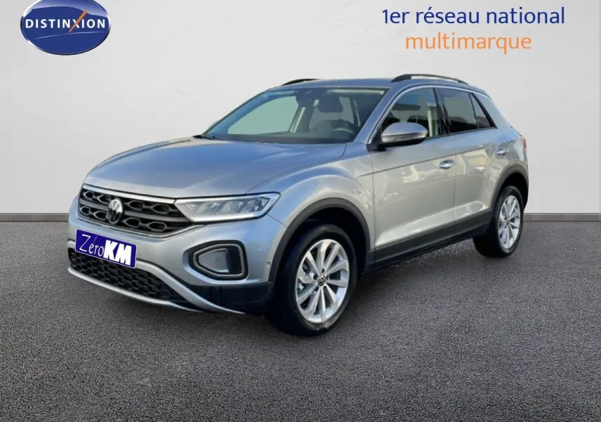 Vue 3/4 avant d'un Volkswagen T-Roc gris pyrite métallisé avec jantes alliage et calandre noire distinctive.