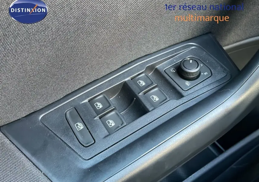 Gros plan sur les commandes de lève-vitres et rétroviseurs côté conducteur du Volkswagen T-Roc gris pyrite 2025.