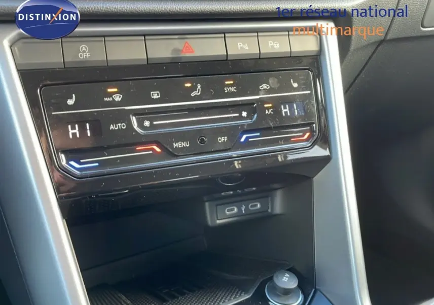 Détail de la console centrale du Volkswagen T-Roc 2025 gris pyrite, avec commandes de climatisation digitale et ports USB visibles.