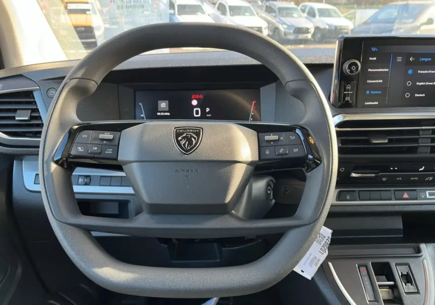 Vue intérieure centrée sur le volant multifonctions du Peugeot Traveller 2025 avec écran tactile et tableau de bord digital.