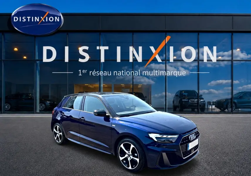 Audi A1 Sportback bleu foncé vue 3/4 avant droit, avec jantes alliage et toit noir devant showroom Distinxion.