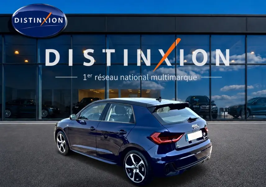 Audi A1 Sportback bleu foncé vue 3/4 arrière droit, avec jantes alliage et becquet arrière sportif.