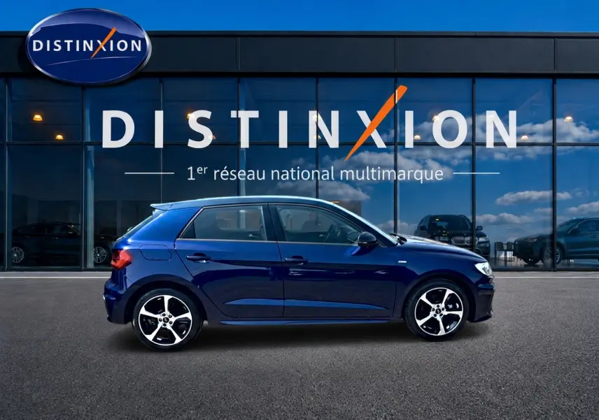 Audi A1 Sportback 30 TFSI S line bleu foncé vue de profil côté gauche devant vitrine Distinxion.