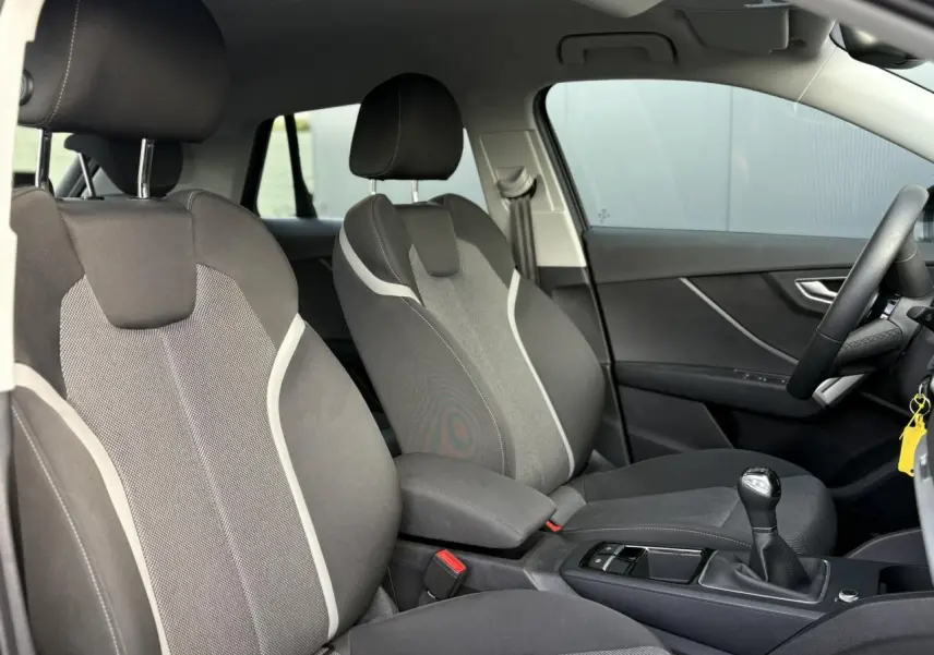 Vue intérieure côté droit montrant les sièges avant gris et la boîte manuelle de l'Audi Q2 30 TDI S-Line 2025.
