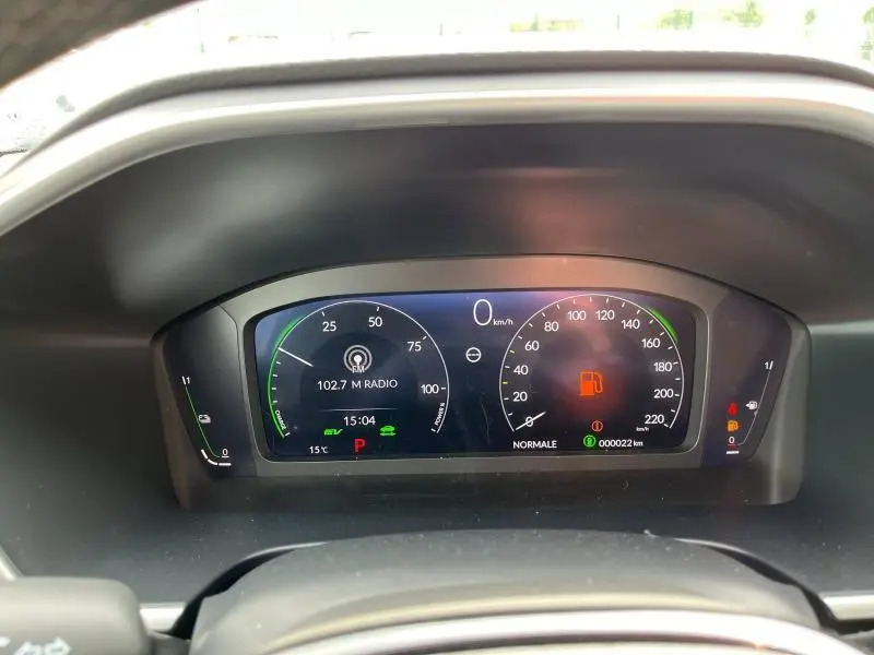 Tableau de bord numérique du Honda CR-V 2024 en blanc, affichant la vitesse, radio et alertes carburant.