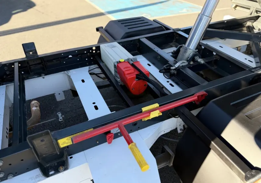 Détail du châssis arrière du Renault Master blanc 2020 avec mécanisme de benne hydraulique visible en extérieur.